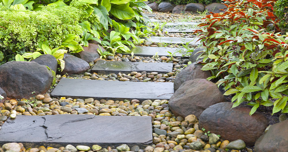 Sandstone stepping stone pathway with cobblestone fill and curbstone edging