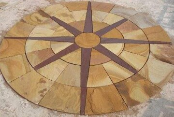 Circular sandstone mosaic with sunburst design